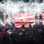 Energetic live Afrobeats concert with performers on a vibrant lit stage and large crowd