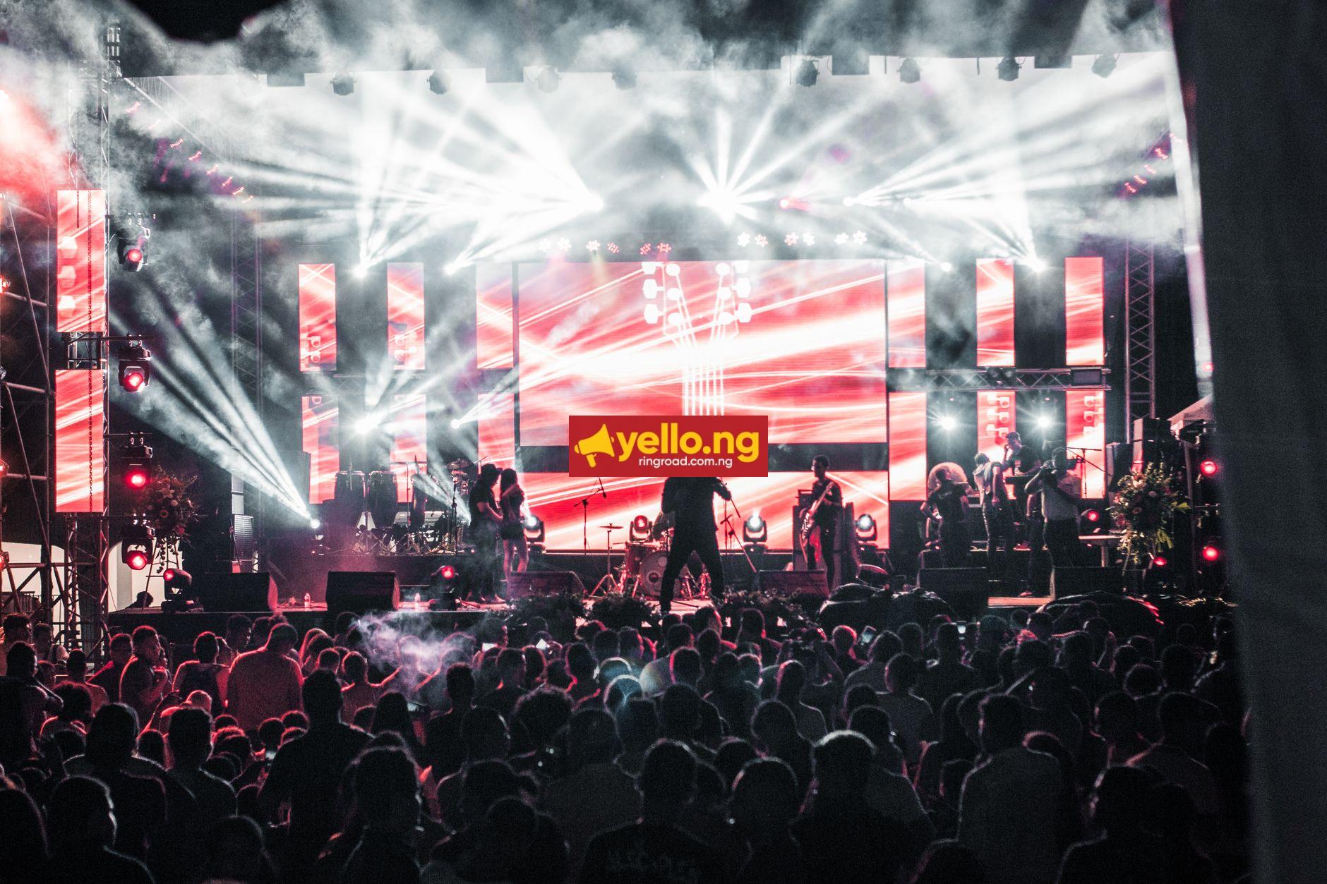 Energetic live Afrobeats concert with performers on a vibrant lit stage and large crowd