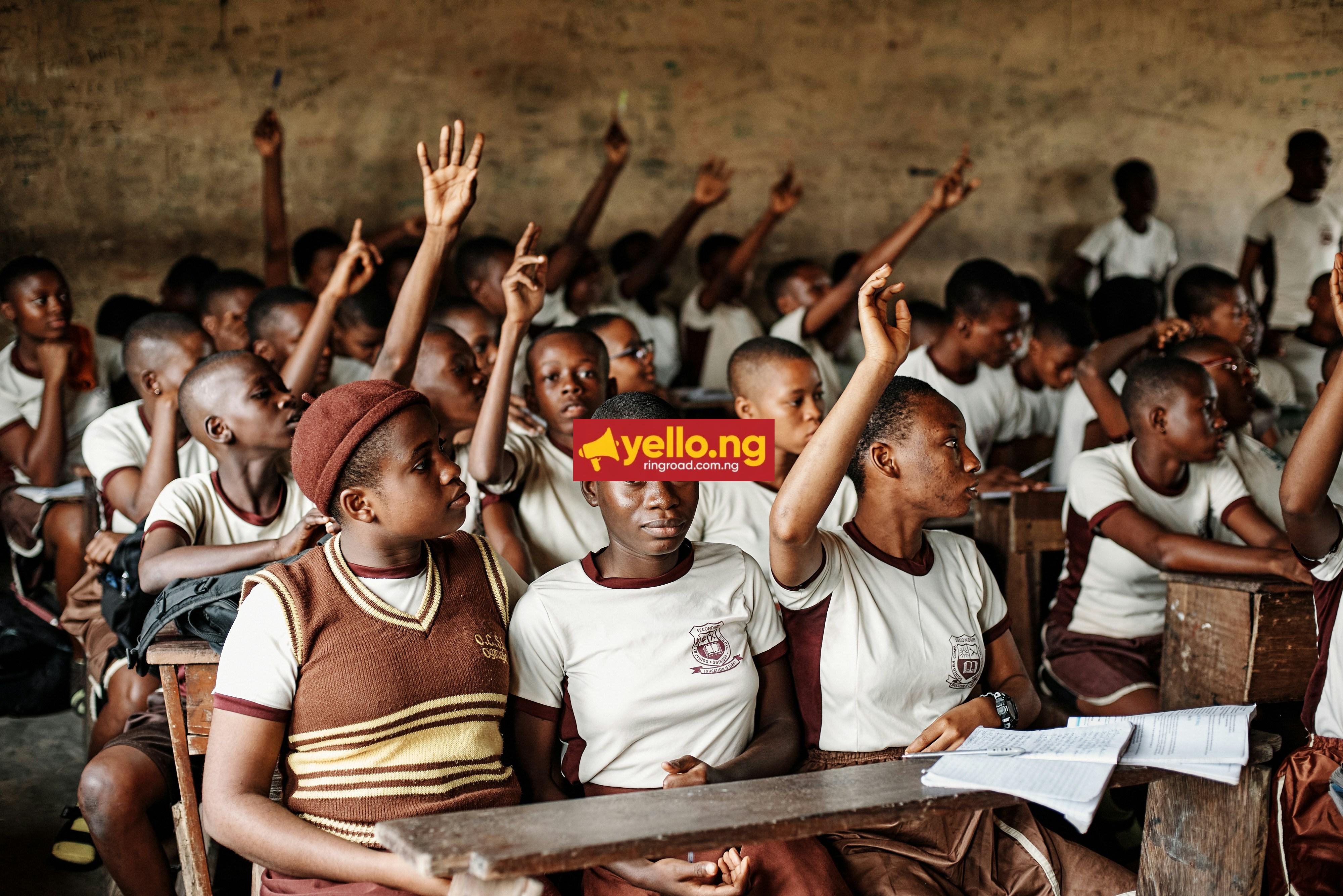 Nigerian secondary school students in Port Harcourt raise hands in a classroom, illustrating civic education and the Student Loan Act's target beneficiaries.