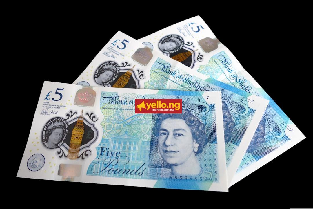British £5 pound sterling banknotes fanned out on black background — GBP to naira exchange rate guide