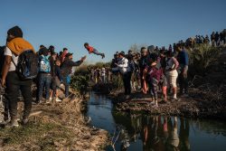 A child passes over a narrow stretch of the Rio Grande at the U.S. border with Mexico on March 29. Driven partly by a surge of Venezuelans seeking asylum, a record number of people migrated from South and Central America to the U.S., with arrivals reaching 2.5 million in the federal fiscal year that ended in October.